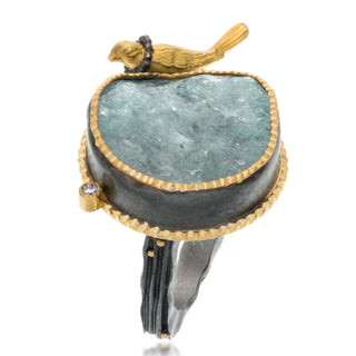 A round aquamarine with a 18kt yellow gold bird