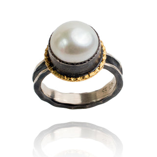 Round pearl set in oxidized silver and 18k gold.